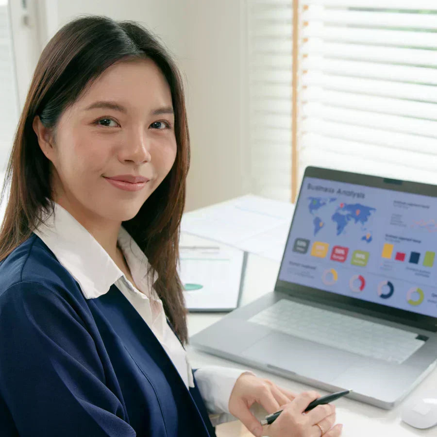 A professional woman wearing a Plaud NotePin on her teal blazer during an office meeting.