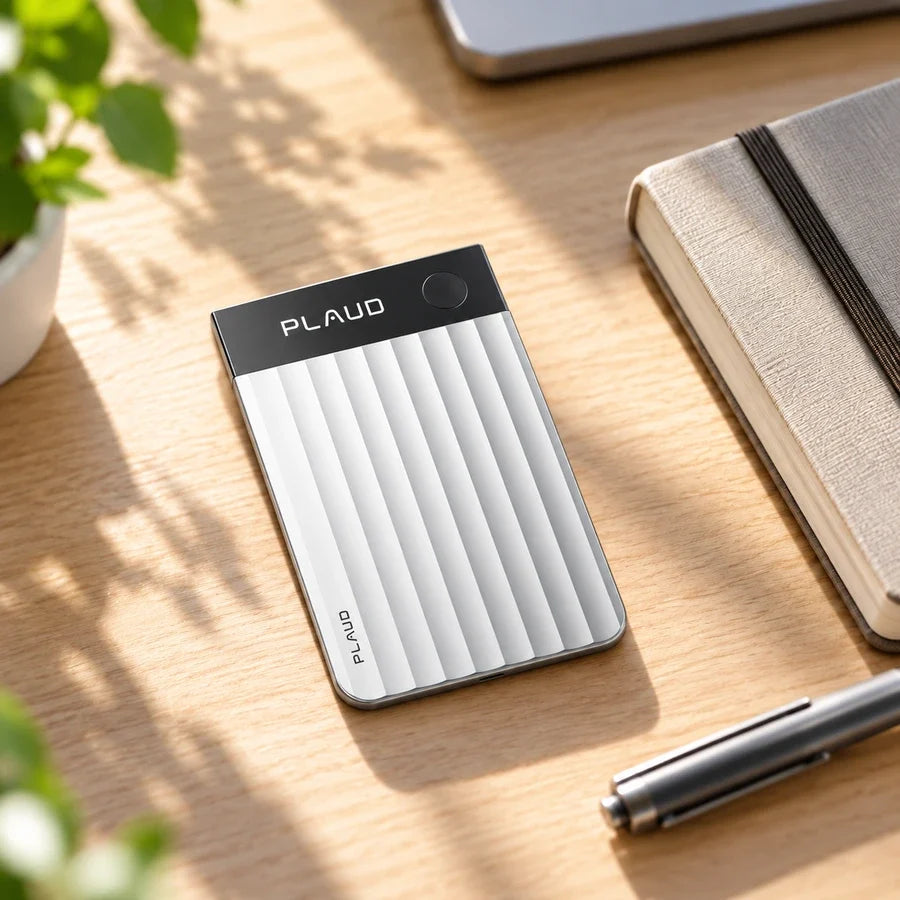 Plaud Note Pro on a desk beside a notebook