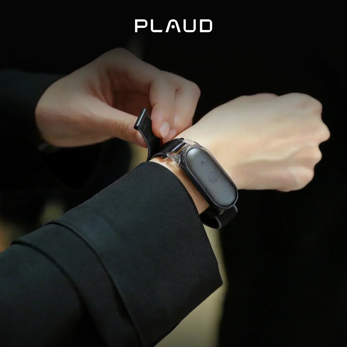 A person wearing a black Plaud NotePin S on a wristband, adjusting the strap.