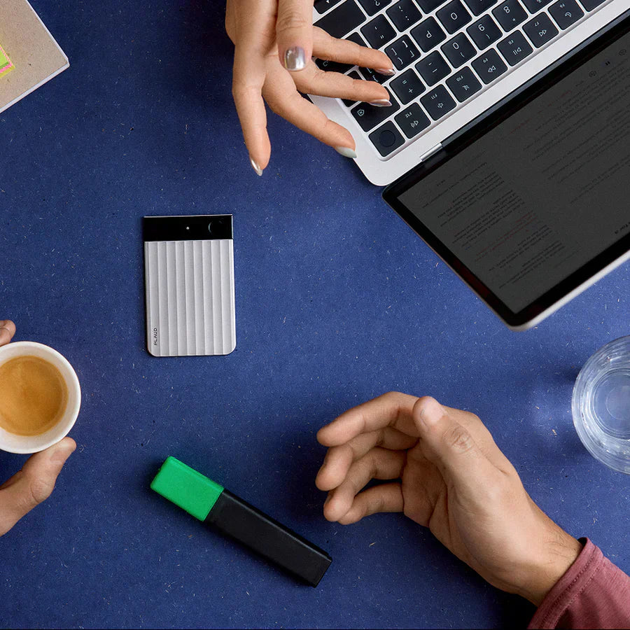 Silver recording device with coffee and laptop on blue surface