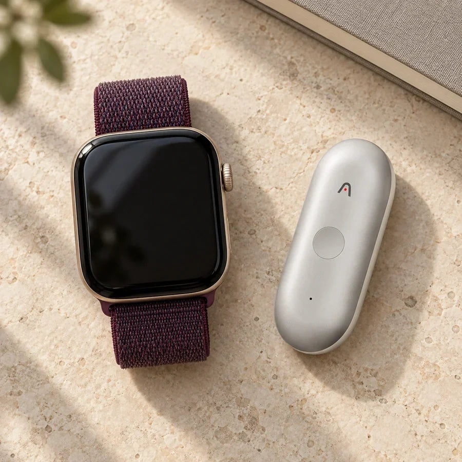 Editorial cover showing an Apple Watch and a silver Plaud NotePin S side by side on a limestone work surface.