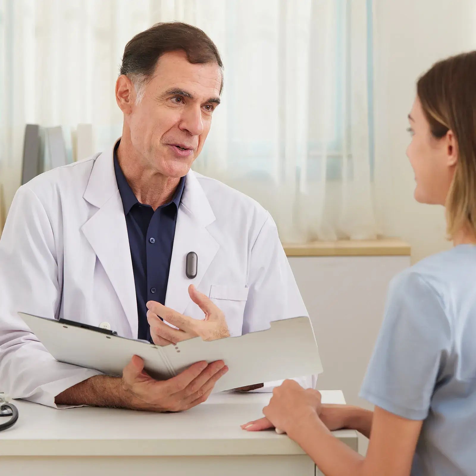 Doctor wearing a black Plaud NotePin during a patient consultation.