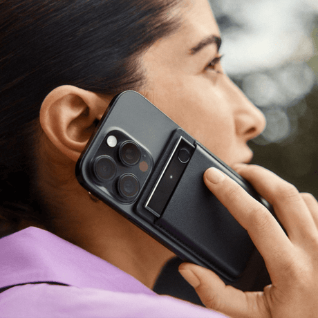 A woman records a phone call with the Plaud Note Pro attached to her phone case.