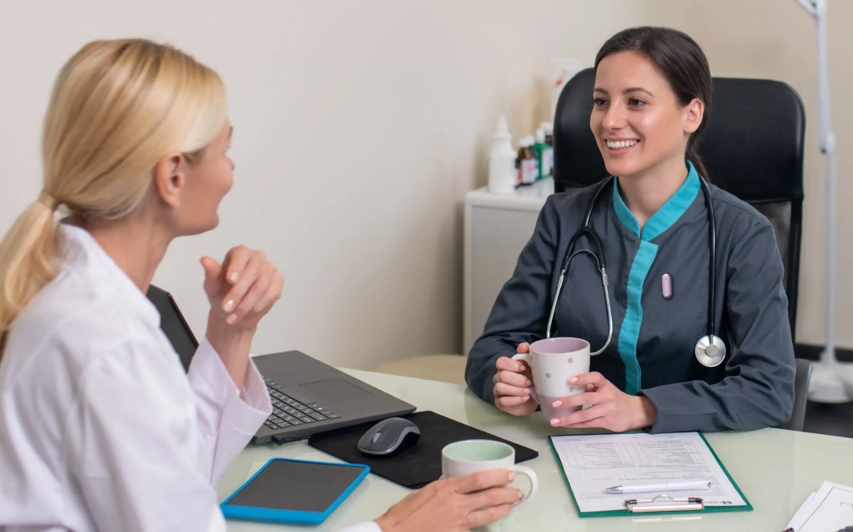 A doctor wearing a Plaud NotePin on her scrubs during a medical consultation.