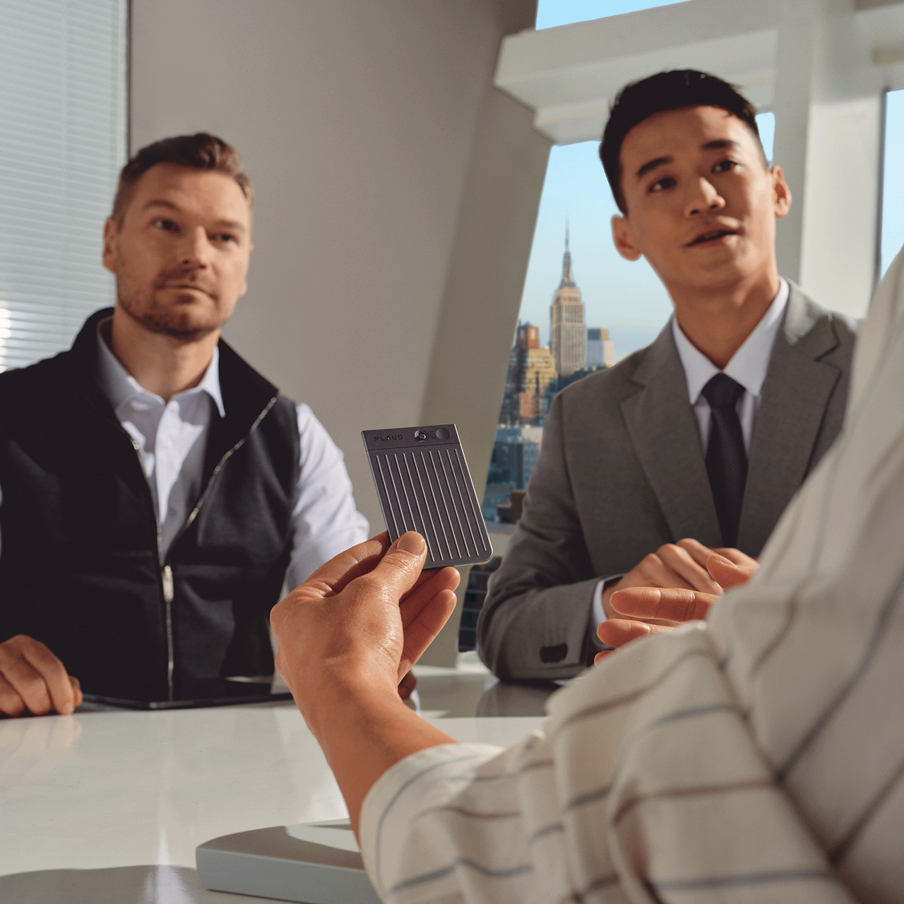 Plaud Note in use during a business meeting; AI voice recorder for capturing conversations and meeting notes.